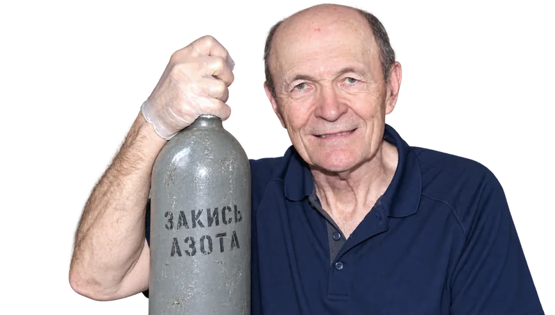 Мужчина в тёмно-синей рубашке-поло держит серый баллон с надписью «Закись азота»